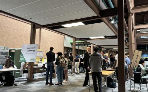 Crowd engaging with student projects during expo
